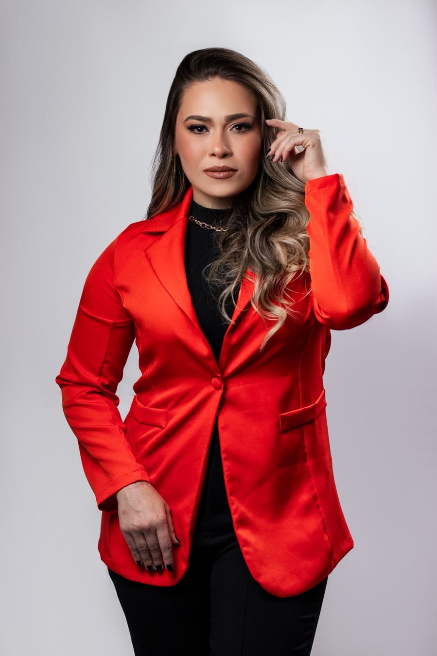 Jéssica Gomes da Silva em retrato profissional, de blazer vermelho